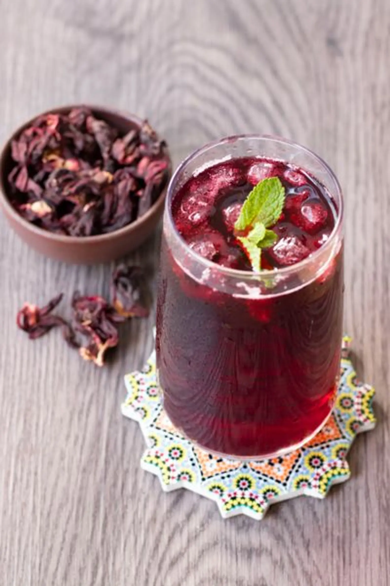 verre de jus de bissap rouge sur sous tasse coloree