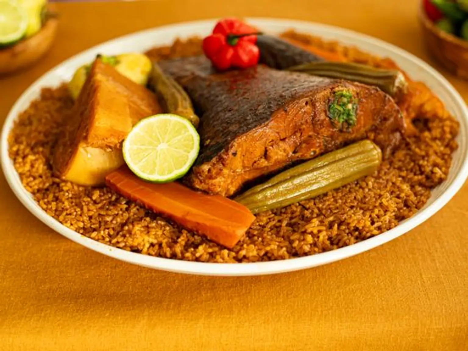 plat de thieboudieune sur nappe jaune vue sur le cote rapprochee sur angle gauche du plat