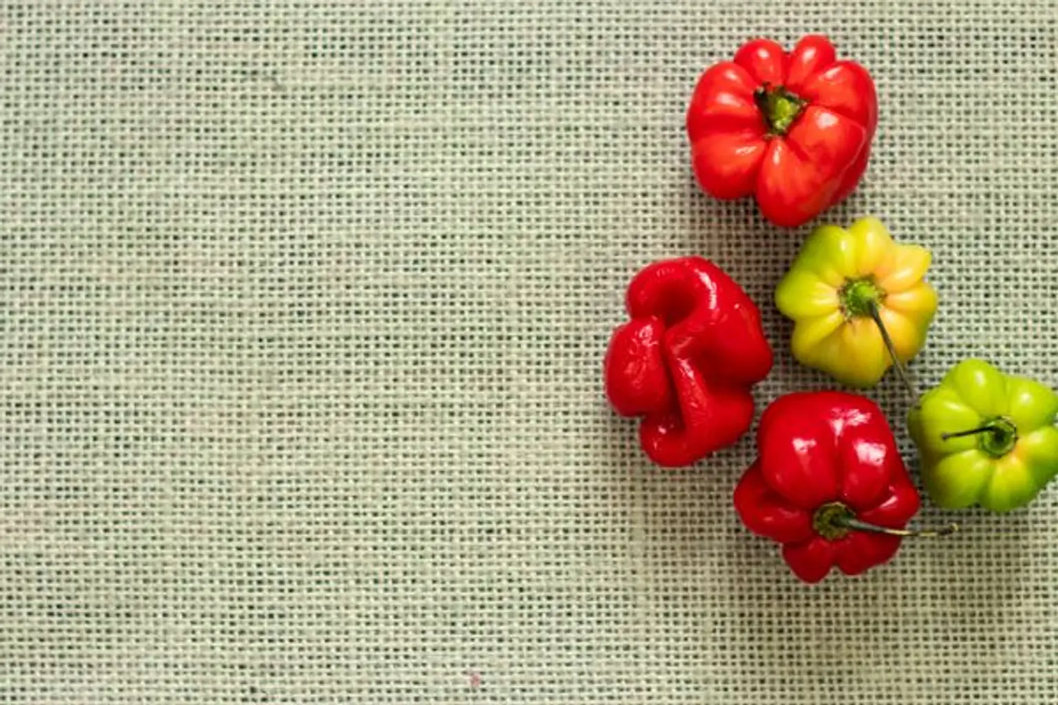 piments rouges et verts sur une nappe en rotin
